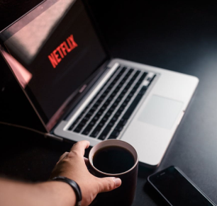 image of laptop with NEtflix on and a cup of coffee